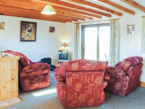 a living room with two couches and a television at Porth View in Saint Mawgan
