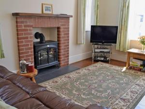 a living room with a couch and a fireplace at Flaxmans in Parkham