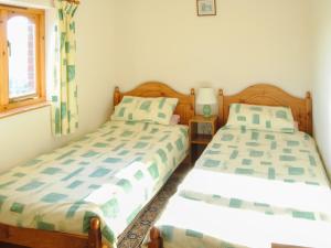 a bedroom with two beds and a window at Porth View in Saint Mawgan