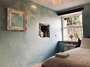 1 dormitorio con cama y espejo en la pared en Foal Barn Cottages - The Smithy - Spennithorne, en Middleham