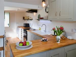 a kitchen with a bowl of fruit on a wooden counter at Pheasant Lodge in Mattishall