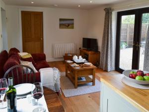 a living room with a couch and a table at Pheasant Lodge in Mattishall