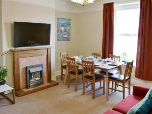 a dining room with a table and a fireplace at Seasands in Sheringham