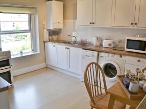 a kitchen with a table and a washing machine at Seasands in Sheringham
