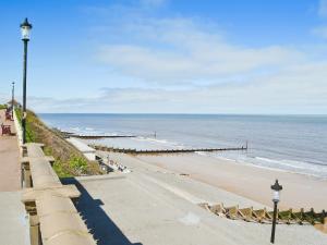 a view of a beach with a pier and the ocean at Seasands in Sheringham