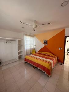 um quarto com uma cama e uma ventoinha de tecto em Viento Casa los 4 elementos em Cancún