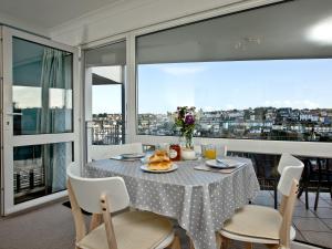 a dining room with a table with a view of a city at Turnstone - 2 Linden Court in Brixham
