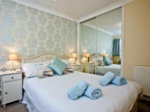 a bedroom with two beds with blue towels on them at Turnstone - 2 Linden Court in Brixham