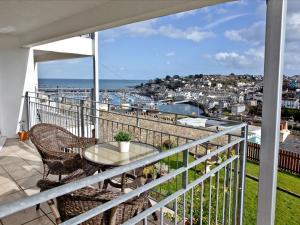 a balcony with a table and chairs and a view at Turnstone - 2 Linden Court in Brixham