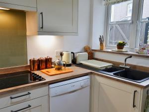 uma cozinha com um lavatório e uma bancada em The Cottage em Broadstairs