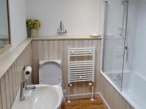 a bathroom with a toilet and a sink and a shower at The Cottage in Broadstairs