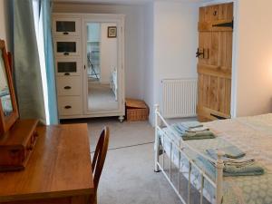 um quarto com uma mesa e uma mesa de jantar e um quarto com uma porta em The Cottage em Broadstairs