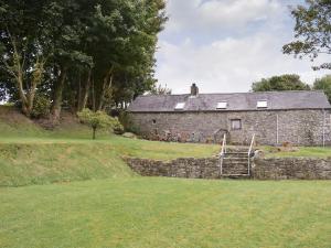 an old stone house with a staircase in front of it at Ty Christian in Blaencelyn