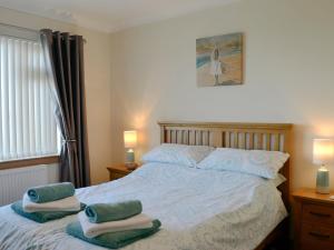 a bedroom with a bed with towels on it at Bayshiel in Sandhead