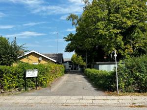 a driveway leading to a house with a sign in front at Cozy Room in the heart of Rødby! 5km from Femern & Puttgarden! in Rødby