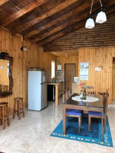塔爾卡的住宿－Cabaña El Sol Pehuenche Cordillera Talca SanClemente，厨房配有桌椅和冰箱。