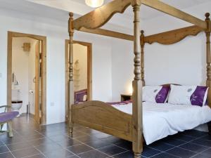 a four poster bed in a bedroom with a tile floor at The Place 2b in Tresmeer