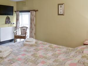 1 dormitorio con 1 cama y 1 silla en Chaffcuttters, en East Down