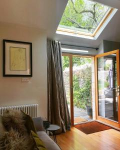 a living room with a skylight and a glass door at The Little Barn @ Bath With LARGE Hot Tub in Bath