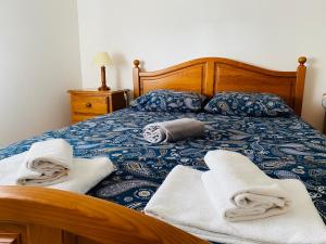 una camera da letto con un letto con asciugamani sopra di SwordFish Beach Apartment a Peniche