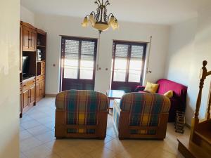 un soggiorno con due sedie e un tavolo di SwordFish Beach Apartment a Peniche