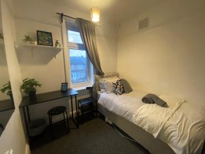 1 dormitorio con cama, escritorio y ventana en Room 2 Peaceful stay Near Derby City Centre, en Derby