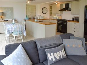 a living room with a blue couch and a kitchen at The Old Smithy in Kea