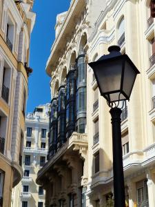 uma luz de rua em frente a um edifício em Centro Madrid. Plaza Mayor. Puerta del Sol. Opera. em Madrid