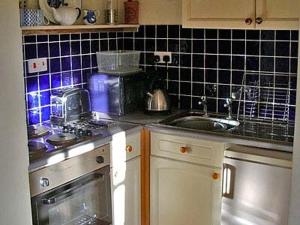 a kitchen with a sink and a stove top oven at Stepping Gate Cottage in Scalby