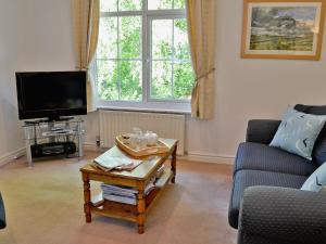 a living room with a tv and a coffee table at Hope Cottage in Lindale