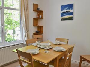 a dining room table with chairs and a wooden table with wine glasses at Hope Cottage in Lindale