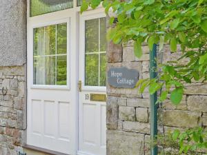 a white door with a sign on the side of a building at Hope Cottage in Lindale