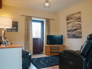 a living room with a tv and a couch and a televisionictericter at Swallow Cottage in Ferryhill