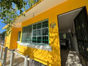 uma casa amarela com uma janela e uma porta em Viento Casa los 4 elementos em Cancún