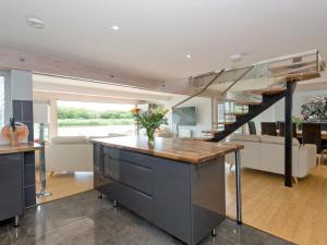 a kitchen with a staircase and a living room at Silver Dawn in Horning