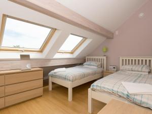 two beds in a attic bedroom with two windows at Silver Dawn in Horning