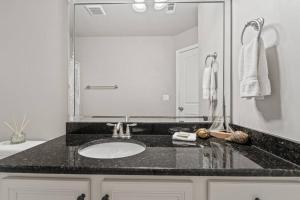 une salle de bain avec un lavabo et un grand miroir dans l'établissement Emerald Beach Cottage, Walk to the Beach!, à Inlet Beach