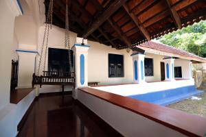 a porch of a house with a swing at Srivilas in Pudunagaram
