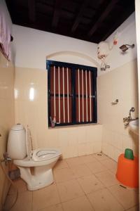 a bathroom with a toilet and a window at Srivilas in Pudunagaram