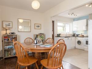 a kitchen and dining room with a wooden table and chairs at Gorwel Glas in Fishguard