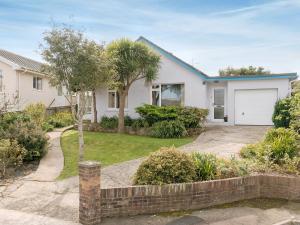 een wit huis met een garage en palmbomen bij Gorwel Glas in Fishguard