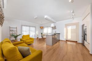 a living room with a yellow couch and a kitchen at Sea Moon Lanzarote in Playa Blanca