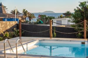 a swimming pool with a hammock around it at Sea Moon Lanzarote in Playa Blanca