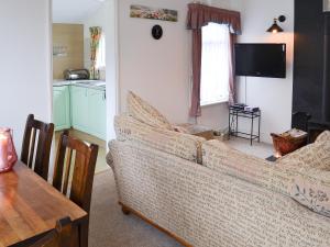 a living room with a couch and a table at Little Whiteleigh in Week Saint Mary