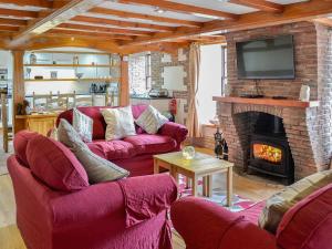 - un salon avec des canapés rouges et une cheminée dans l'établissement Bridge House - Ukc1340, à North Molton