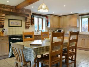 a kitchen with a wooden table and chairs and a table at Howards End in Leysters