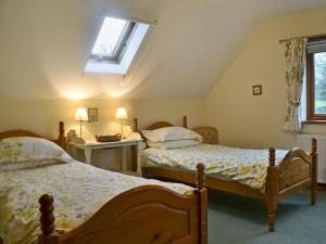 a bedroom with two beds and a skylight at Howards End in Leysters