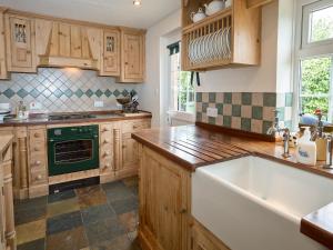 a kitchen with wooden cabinets and a green stove top oven at Crabtrees in Ringstead