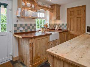 a kitchen with wooden cabinets and a counter top at Crabtrees in Ringstead