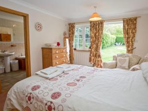 a bedroom with a large bed and a window at Crabtrees in Ringstead